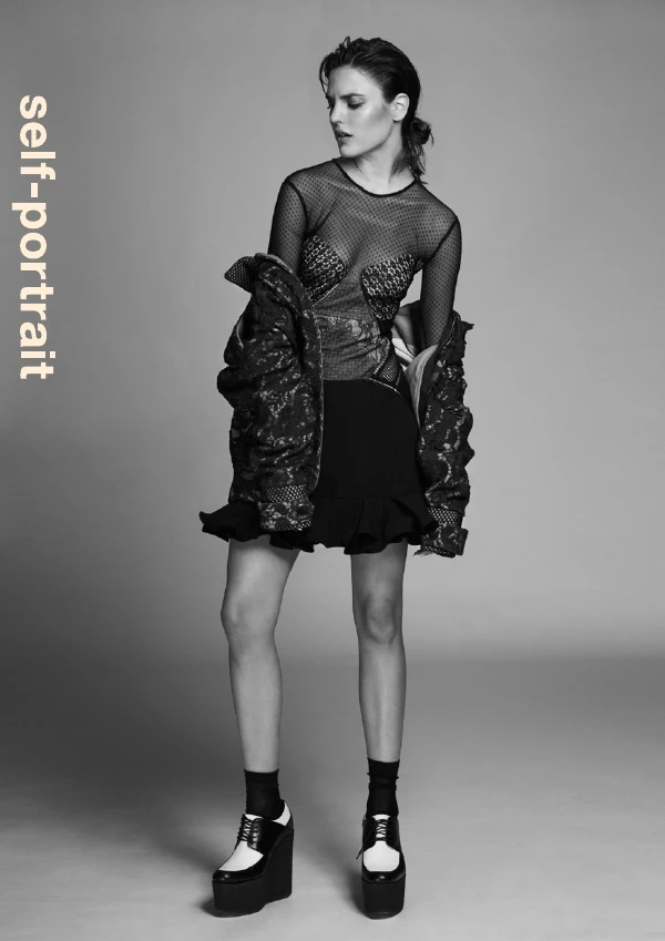 Black-and-white portrait with the vertical Self-Portrait wordmark.